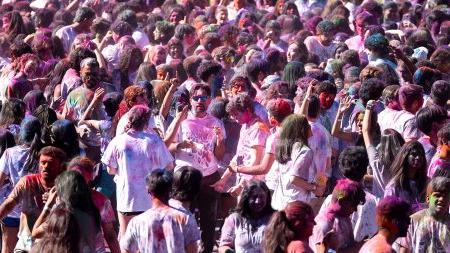 Crowd of students on a field celebrating Holi