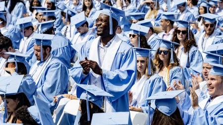 Students standing and clapping at Commencement