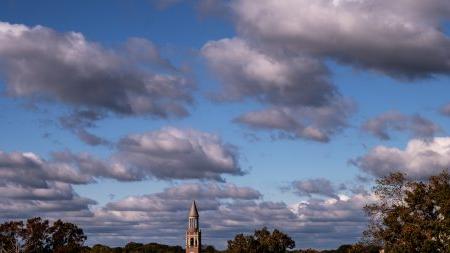 Long-range aerial image of Morehead-Patterson Bell Towr on a partly cloudy afternoon on the campus of U.N.C Chapel Hill.